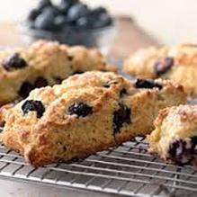 Freshly baked blueberry scones cooling on a wire rack.
