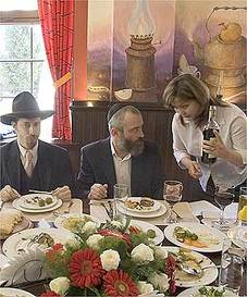 A family meal with traditional attire and a waitress serving food.