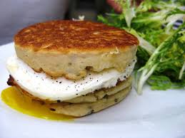 Stack of savory potato pancakes with a dollop of sour cream and herbs.