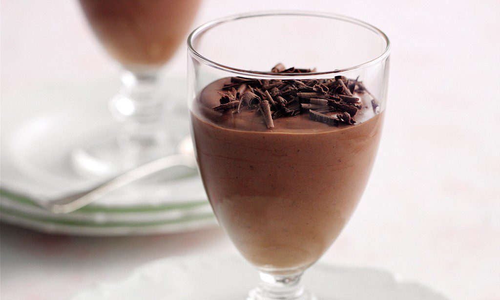 Chocolate mousse topped with chocolate shavings in a glass.
