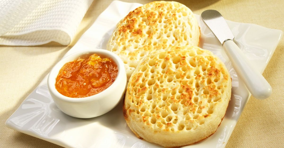 Plate of crumpets with a bowl of marmalade jam.