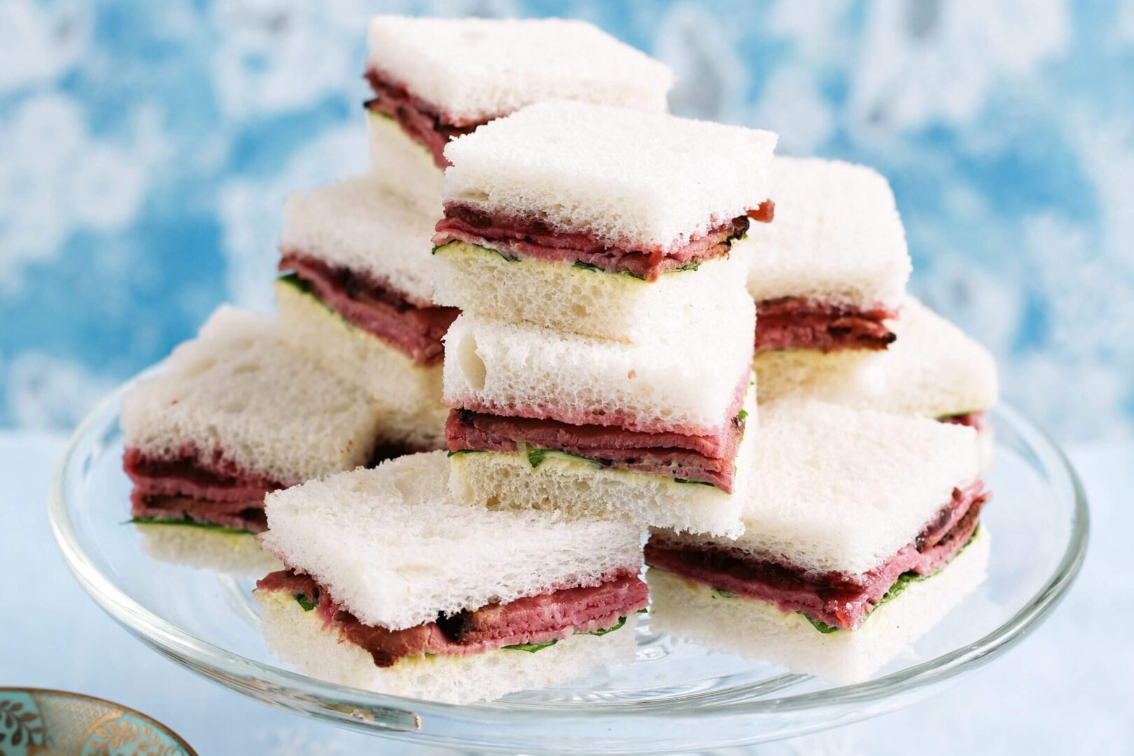 Stack of frosted layered dessert bars with jam filling.