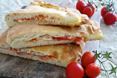 Close-up of stacked focaccia bread with cherry tomatoes.