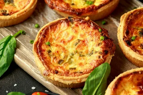 Golden mini quiches with herbs and cheese.