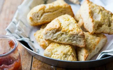 Golden-brown scones with a flaky texture on a plate.