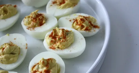 Plate of deviled eggs garnished with paprika.