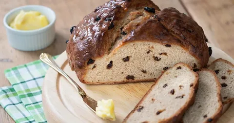 Freshly baked raisin bread with a pat of butter.
