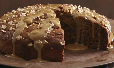 Close-up of a moist cake with glaze and nuts.