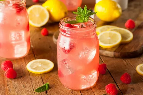 Refreshing pink lemonade in a mason jar with ice and mint.