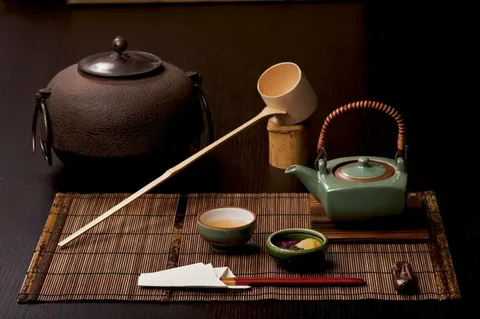 Traditional Japanese tea ceremony setup with teapot, cups, and utensils.