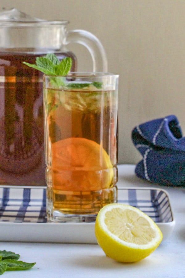 A refreshing iced tea with a lemon slice and mint garnish.