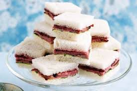 Stack of layered dessert bars with a fruit filling and white topping.