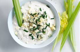 Creamy dip with herbs and celery sticks on the side.
