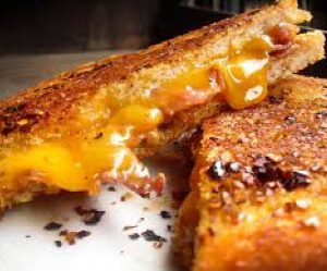 Close-up of a crispy grilled cheese sandwich with melted cheddar.