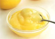 A bowl of creamy lemon curd with a spoon.