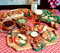 A festive spread of sandwiches and dips on a checkered tablecloth.