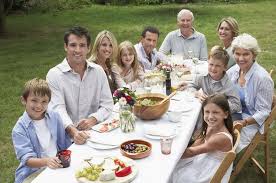 Family enjoying an outdoor meal together on a sunny day.