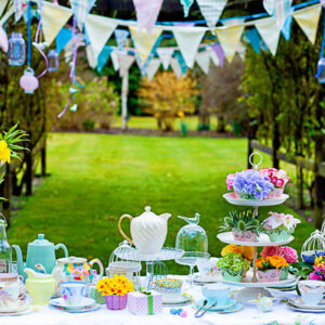 A whimsical outdoor tea party setup with colorful decorations and treats.