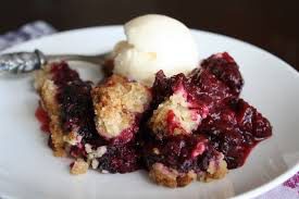 A serving of blackberry cobbler with a scoop of vanilla ice cream.