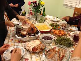 A festive table with a carved turkey and traditional side dishes.