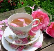 Elegant floral teacup with rose petals and fresh pink roses.