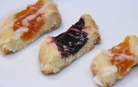 A triangular pastry with blueberry topping on a white plate.