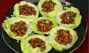 Lettuce cups filled with savory minced meat and garnished with herbs.