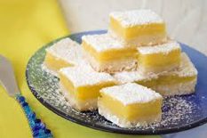 Plate of powdered sugar-topped lemon bars.