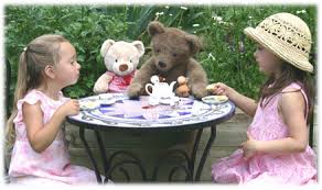 Children having a tea party with teddy bears.