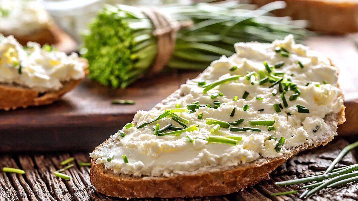Cream cheese spread on bread topped with fresh chives.