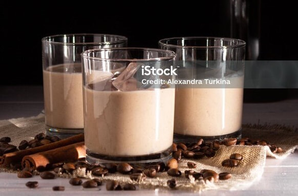 Three glasses of creamy chocolate mousse with chocolate shavings.