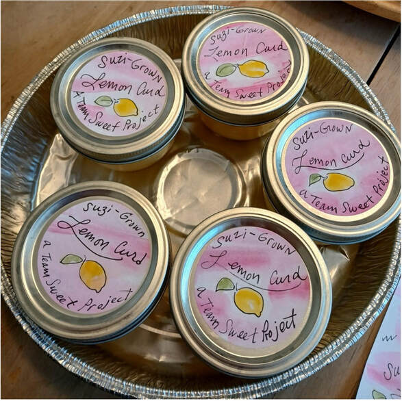 Four jars of lemon honey on a silver tray.