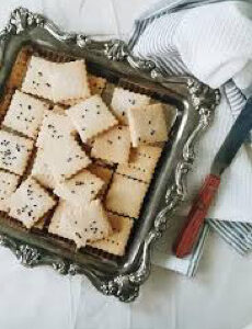 A tray of square crackers sprinkled with seeds.