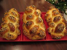 Three braided challah breads on a red tray.