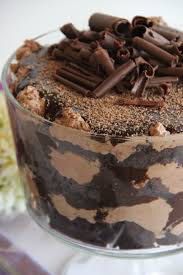 A rich chocolate trifle dessert with creamy layers and chocolate shavings on top.