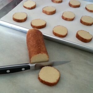 Sliced bread roll next to a baking tray with arranged slices.