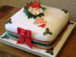 Decorative Christmas cake with red bow and festive flowers.