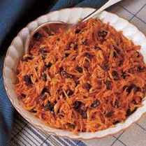 Bowl of shredded carrot salad with raisins.