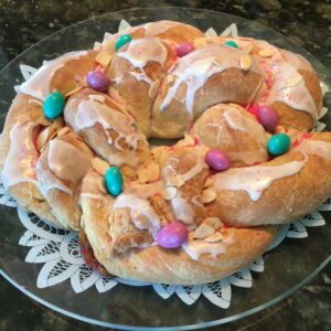 A festive pastry wreath decorated with colorful candies and icing.