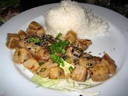 Grilled chicken with white rice and garnished with green onions.