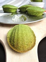 Close-up of a green ridged pastry on a wooden board.