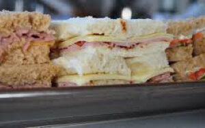 Close-up of a ham and cheese sandwich with toasted bread.