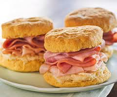 Three ham and egg breakfast sandwiches on a plate.