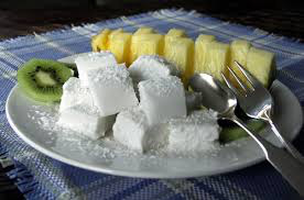Plate with white coconut cubes and sliced pineapple.