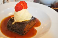 A dessert with vanilla ice cream and strawberry on top.