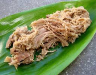 Pulled pork served on a green leaf.
