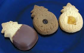 Assorted cookies including a chocolate-dipped and a gingerbread man cookie on a blue plate.