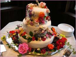 Three-tiered cake adorned with colorful flowers.