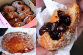Assorted powdered and chocolate-glazed donuts on a tray.