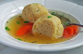 Two round bread dumplings in clear broth with vegetables.